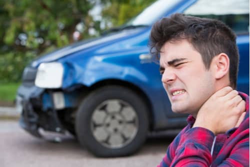Male with whiplash from crash Hesperia car accident lawyer concept