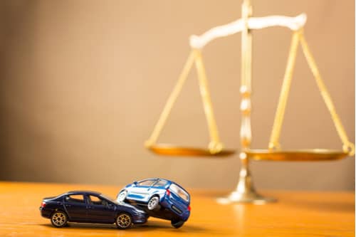 toy cars and brass scales, Victorville car accident lawyer concept
