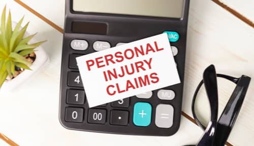 Calculator and sign showing personal injury claims process, Victorville personal injury lawyer concept
