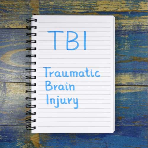 Irvine traumatic brain injury lawyer concept, TBI acronym in notebook