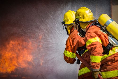 Firefighters spray pressurized water Santa Ana burn injury lawyer concept