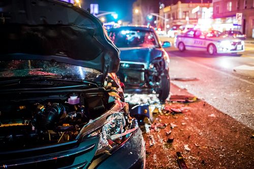 Image is of a car accident scene at night with lots of lights, concept of Fullerton car accident lawyer