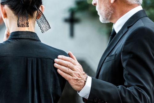 Image is of a man and a woman dressed in black, mourning a death, concept of Fullerton wrongful death lawyer