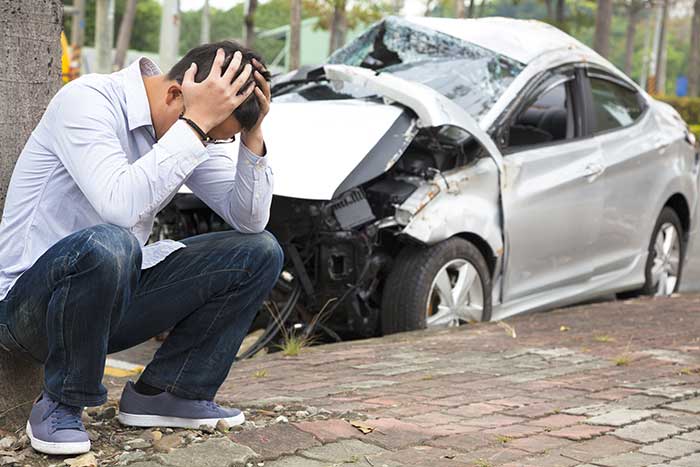 A man is holding his head after a car accident