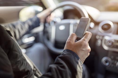 A man texting while driving in Orange County, greatly increasing his chance of causing an accident.