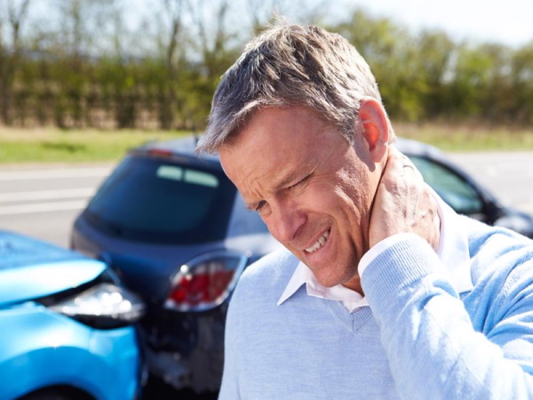 A man holding his injured neck after being rear-ended.