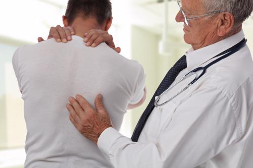 Muscular man suffering from back and neck pain incorrect sitting