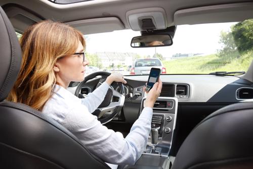 A woman texting while driving.