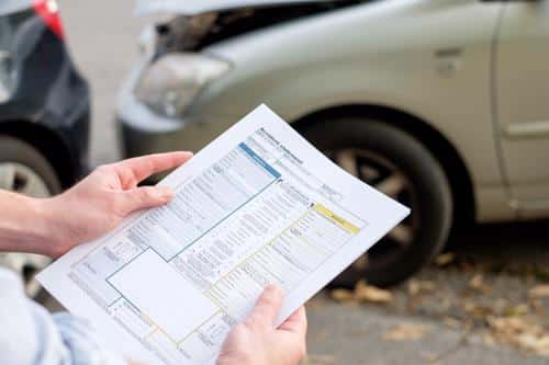 An insurance adjuster reviewing damage after an Orange County car accident.